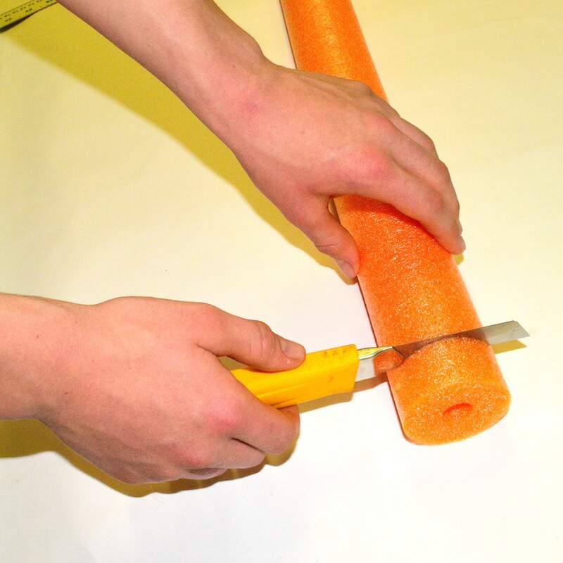 Cutting out the pool noodle to use as a nose bumper, to make a water rocket