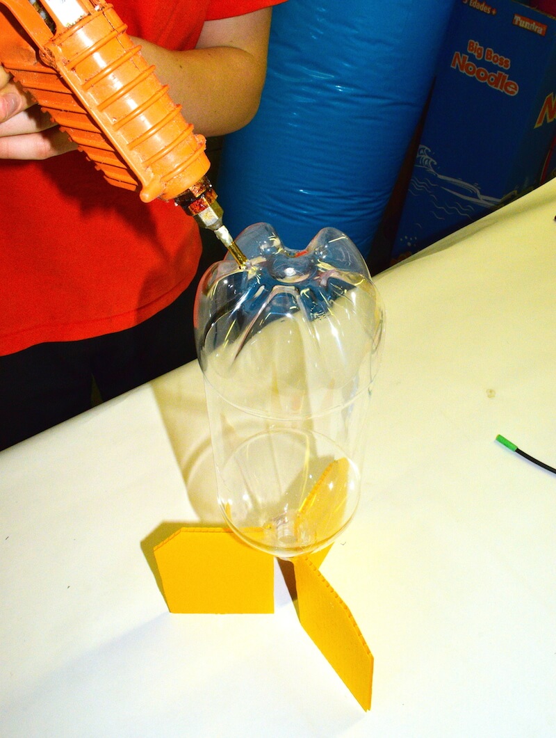 Putting glue on to hold the nose bumper on the front, to make a water rocket